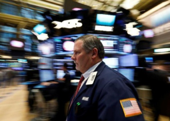 Một nhà giao dịch làm việc tại Sở Giao dịch Chứng khoán New York (NYSE) hôm 7/2 - Ảnh: Reuters.