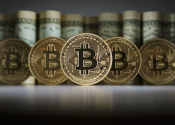 BERLIN, GERMANY - FEBRUARY 15: In this photo illustration model Bitcoins standing in front of Dollar bills on February 15, 2016 in Berlin, Germany. (Photo Illustration by Thomas Trutschel/Photothek via Getty Images)